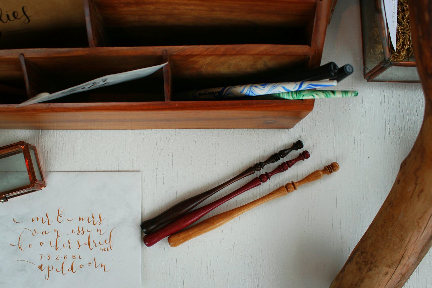 Calligraphy pens and an addressed envelope on a desk.